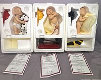 All three figurines in styrofoam inserts with helmets, accessories and certificates