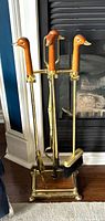 front view of complete brass fireplace tool set with duck head handles