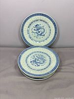 Stack of six blue and white dragon motif plates
