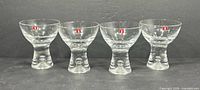 Front view of four Iittala Tapio glasses showing overall form and logo stickers