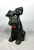 Front view of black ceramic Scotty dog figurine showing face eyes and tongue