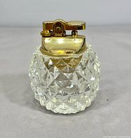 Front view of cut crystal table lighter with gold-tone top
