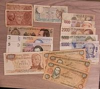 Group view of assorted international banknotes showing denominations and portrait sides