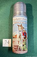 Full view of metal thermos with illustrated Roy Rogers & Dale Evans scene and metal cup lid