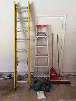 Extension ladder, stepladder, rake, shovel, broom visible