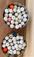Overhead view of both tins showing quantity and variety of golf balls