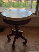 Full view of marble-top pedestal table by window