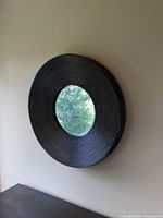 Front view of round mirror with black ribbed frame