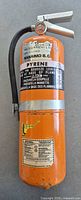 Full view of orange Pyrene 10 lb ABC fire extinguisher with hose and labels visible