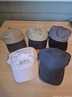 all five caps laid out showing colors and fronts
