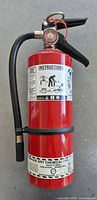 Full view of red 5 lb ABC fire extinguisher with hose and labels
