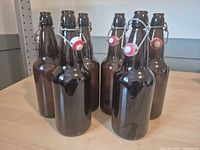 Six brown swing-top bottles grouped on table