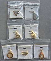 Group shot of seven packaged pendants