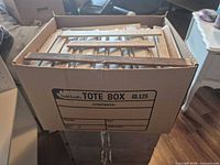 Top view of banker box filled with wood slats