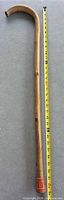 Full length view of wooden cane beside measuring tape