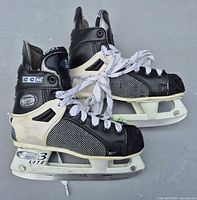 Left and right CCM 552 Tacks skates side view showing holders, blades, boot condition