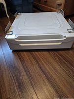 Front view of white metal pedestal with drawer closed