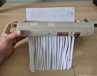Shredder actively cutting lined paper