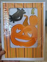 Front of sample card showing pumpkin and crow gel clings in striped border card