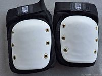Front view of both knee pads showing white caps and eyelets