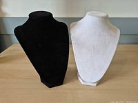 Front view of both necklace display busts showing black and white colors