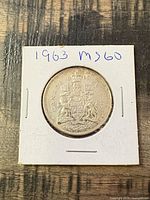 Obverse and reverse views of the 1963 Canada 50 cents coin in holder
