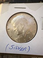 Obverse of 1964 Kennedy half dollar in holder