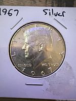 Obverse of 1967 Kennedy half dollar in flip holder