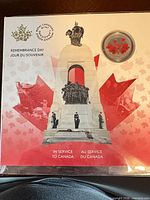 Front of sealed presentation card with coin showing colourized poppy design