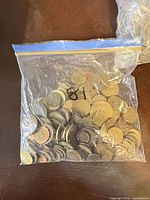 Full view of sealed plastic bag filled with mixed coins