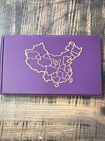 Purple booklet exterior with gold outline map of China