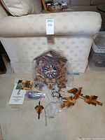 Overview of disassembled cuckoo clock, components, booklet and weights