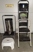 Group view of ladder, platform step supporting trash can, and plastic stool