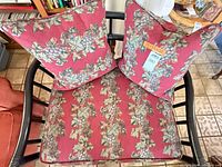Top view showing seat cushion and two pillows with grapevine fabric inside black rattan frame