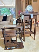 Group shot showing clock on tall table, low table in front, spirit house at base