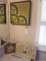 All three framed needlepoints grouped for scale and context