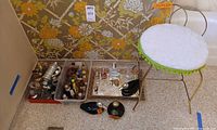 Group shot showing plastic bins of perfume bottles, mirrored tray, loose bottles, and vanity stool