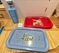 Overall lot showing blue decanter, red tray stack, single blue tray