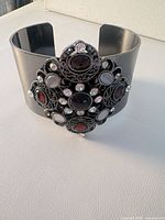 Front view of gunmetal cuff bracelet with central glass cabochon cluster
