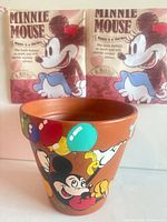 Front view of terracotta planter showing Mickey Mouse and balloons artwork