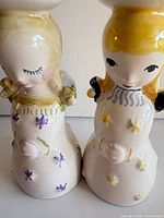 Front view of both Nymolle candleholder figurines