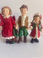 Front view of three Christmas child figurines