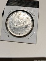 Reverse of 1937 Canada dollar showing canoe voyageur design in cardboard flip