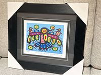 Framed lithograph in protective corners showing entire artwork and black frame