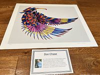 Full view of unframed print and bio card on wood floor