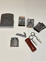 Front view of all items including large RCAF lighter, three match safes, small lighter, knives and sheath