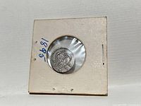 Coin obverse in cardboard flip showing tughra, star and crescent