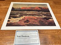 Full view of lithograph and information card on wooden surface