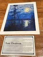 Full view of print and information card on wood floor