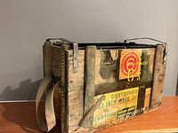 Full view of crate showing exterior paint, stencils, canvas strap and metal handle